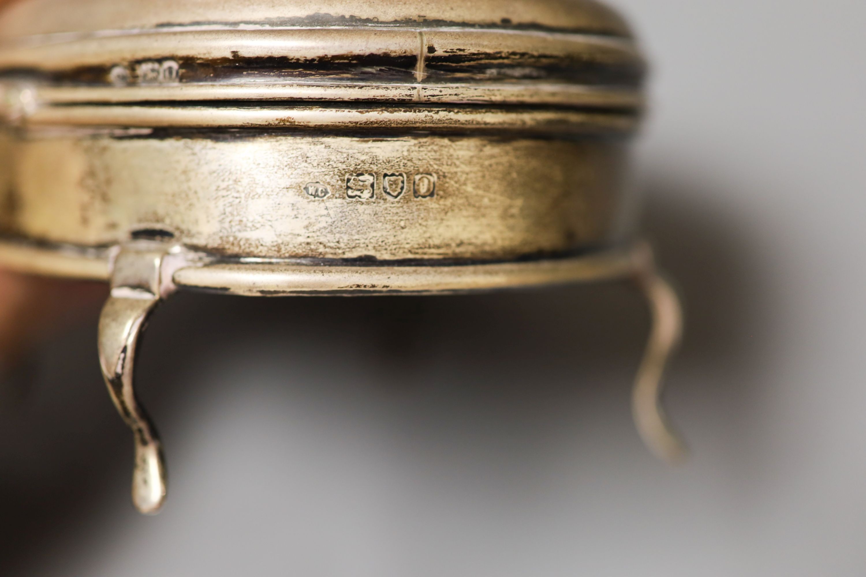 An Edwardian silver oval trinket box, William Comyns, London, 1909, 12.4cm and two round silver mounted glass toilet boxes.
